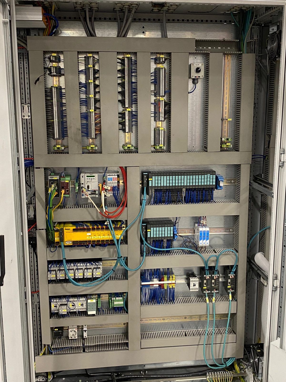 Same industrial control cabinet after rebuild, with dressed and labeled wiring