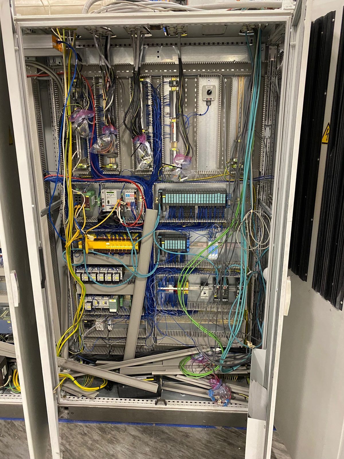 Industrial control cabinet before rebuild, with undressed cable runs