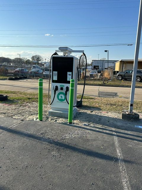 DC fast charger installed on a concrete pad with safety bollards