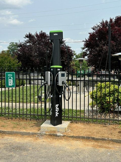 Dual-port EV charging pedestal installed beside a fenced patio