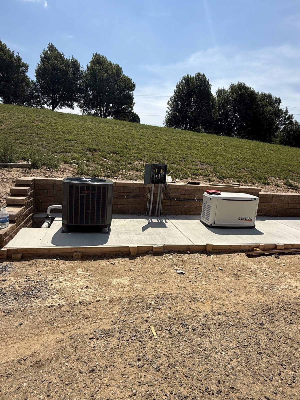 Standby generator on a new concrete pad beside an HVAC unit