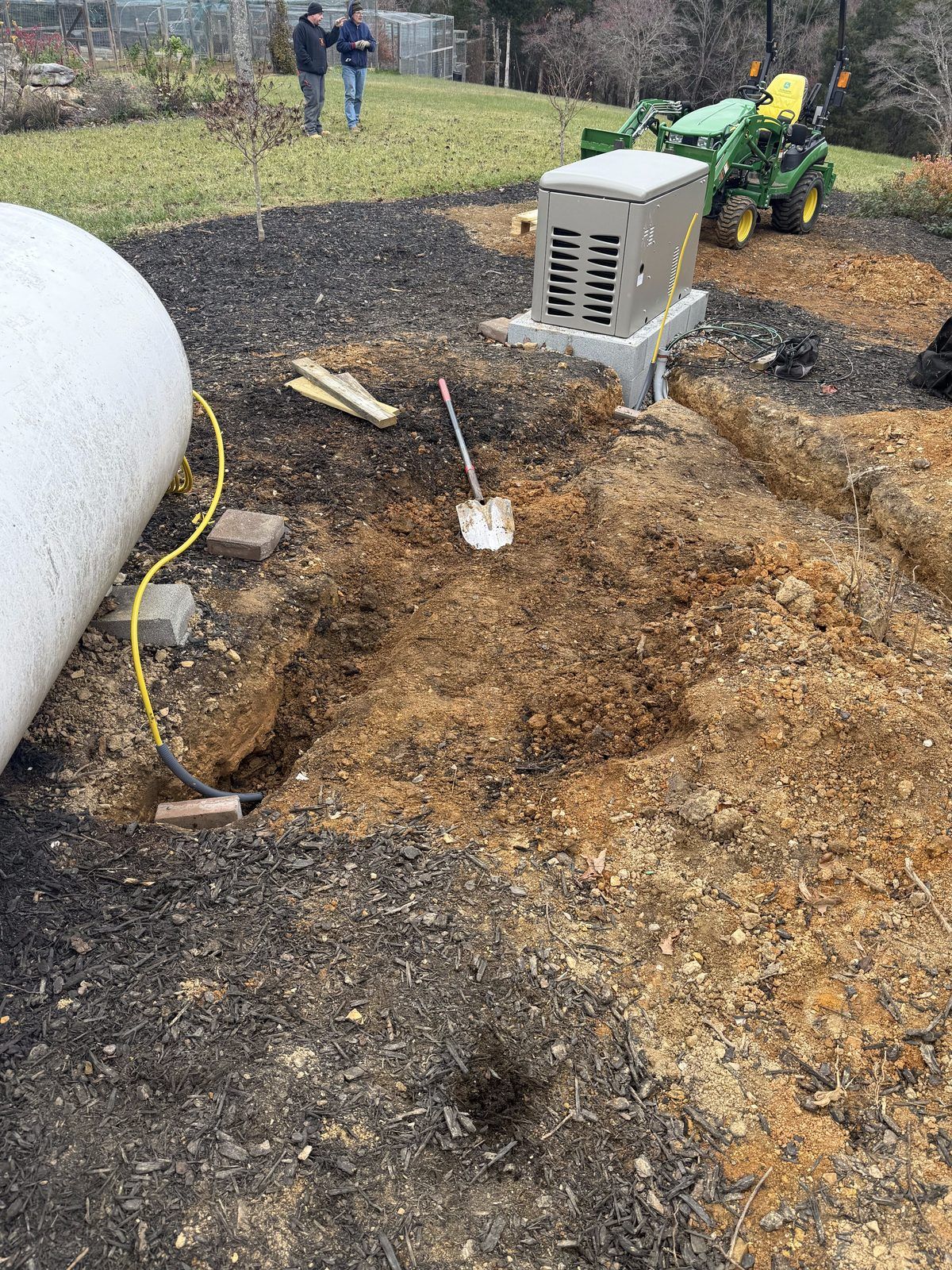 Standby generator set on its pad with the fuel line trench dug to a propane tank
