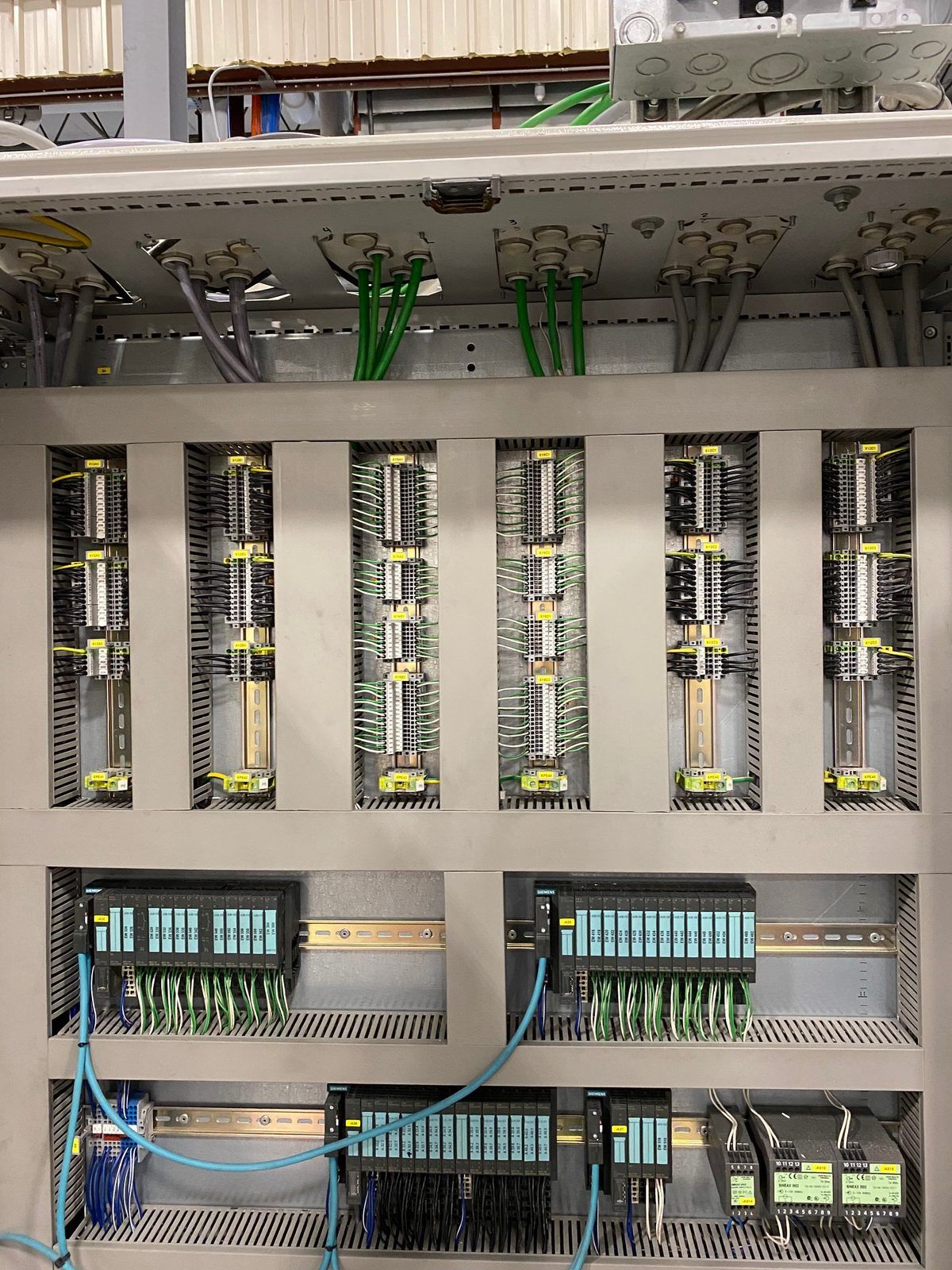 Labeled terminal strips and PLC I/O modules in a control cabinet