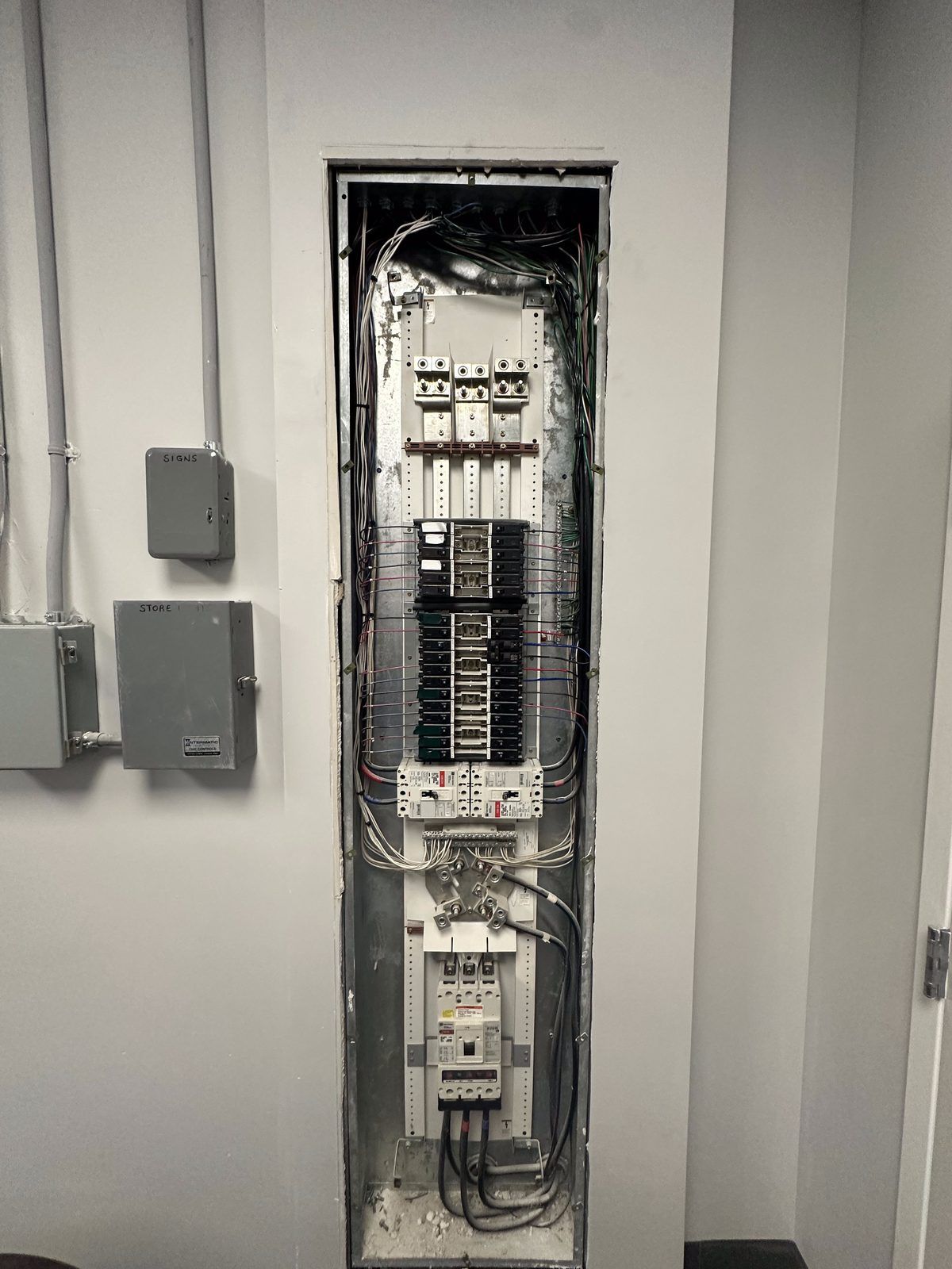Commercial distribution panel with main and branch breaker sections set into a finished wall