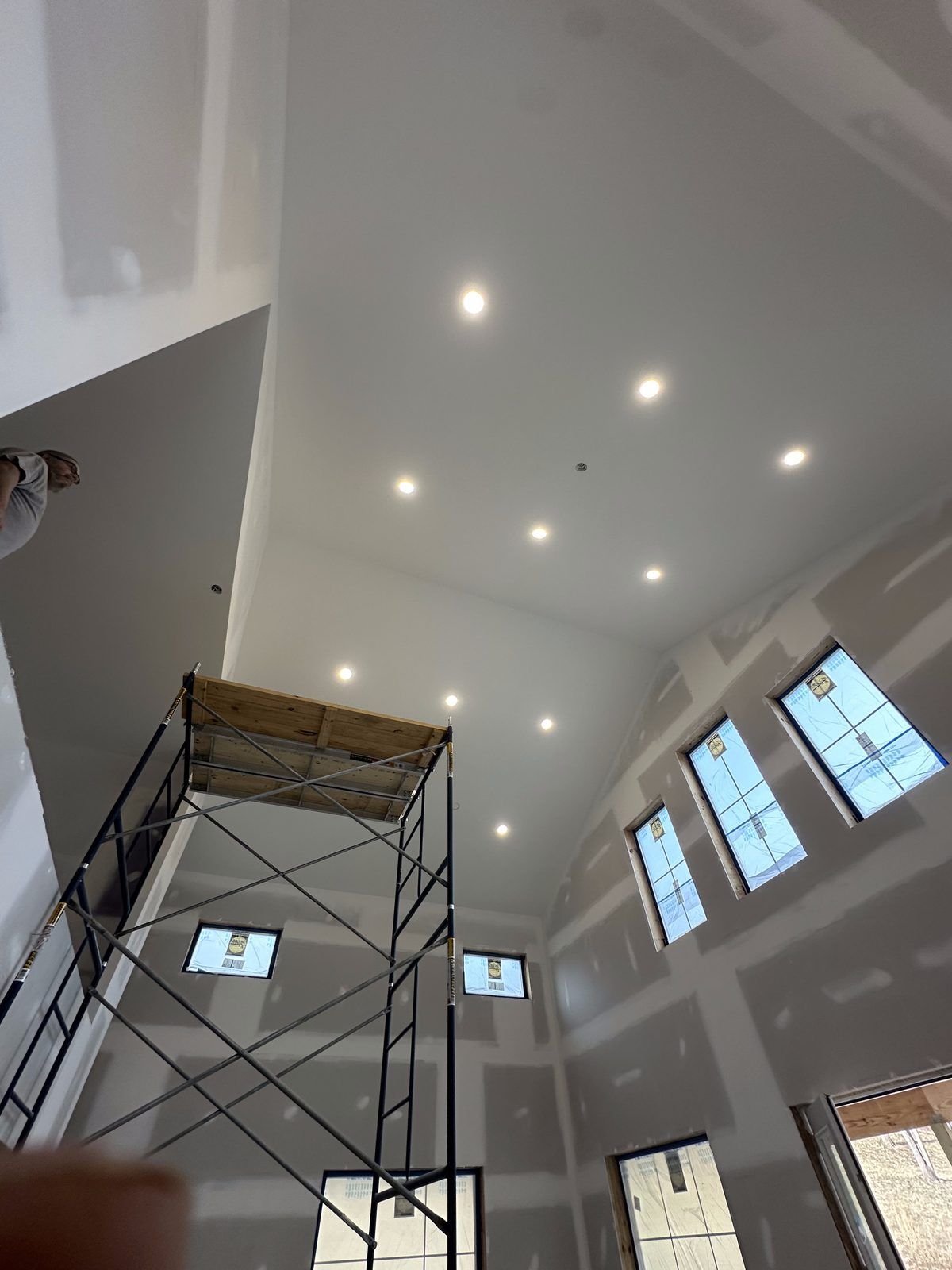 Recessed lighting installed in a vaulted great room ceiling during construction