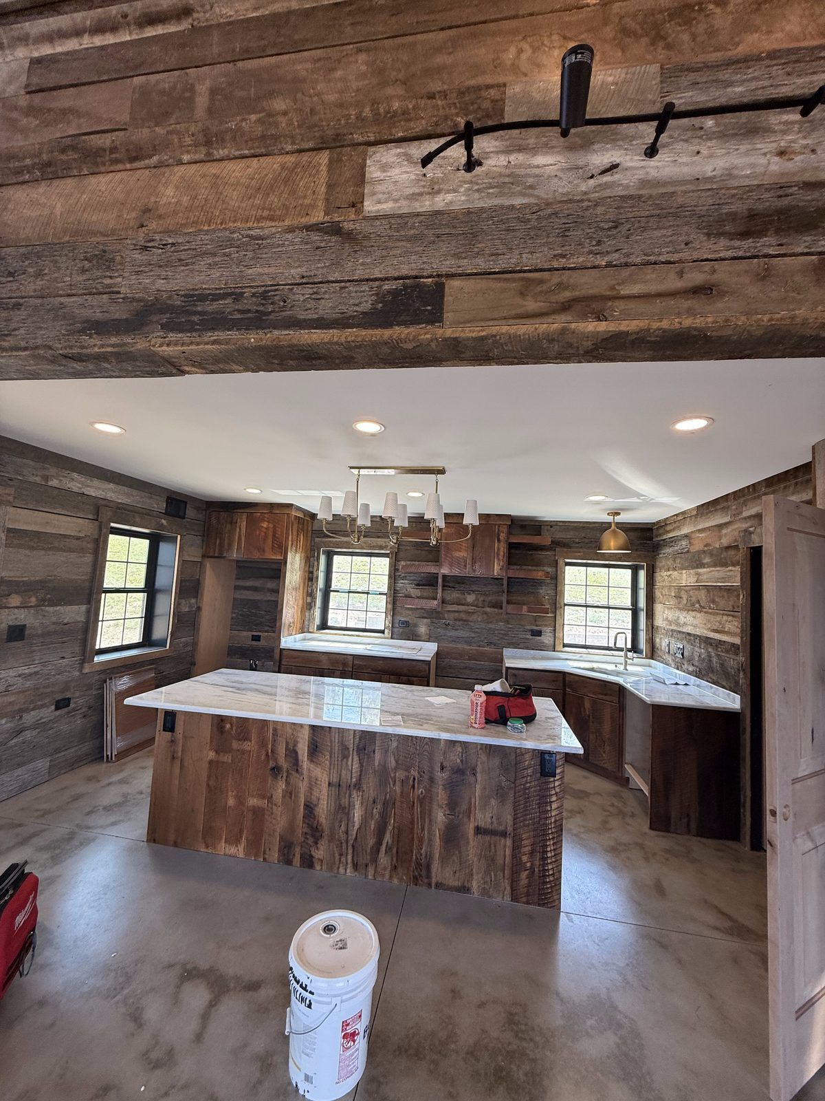 Reclaimed-wood kitchen with recessed lights and a pendant fixture over the island