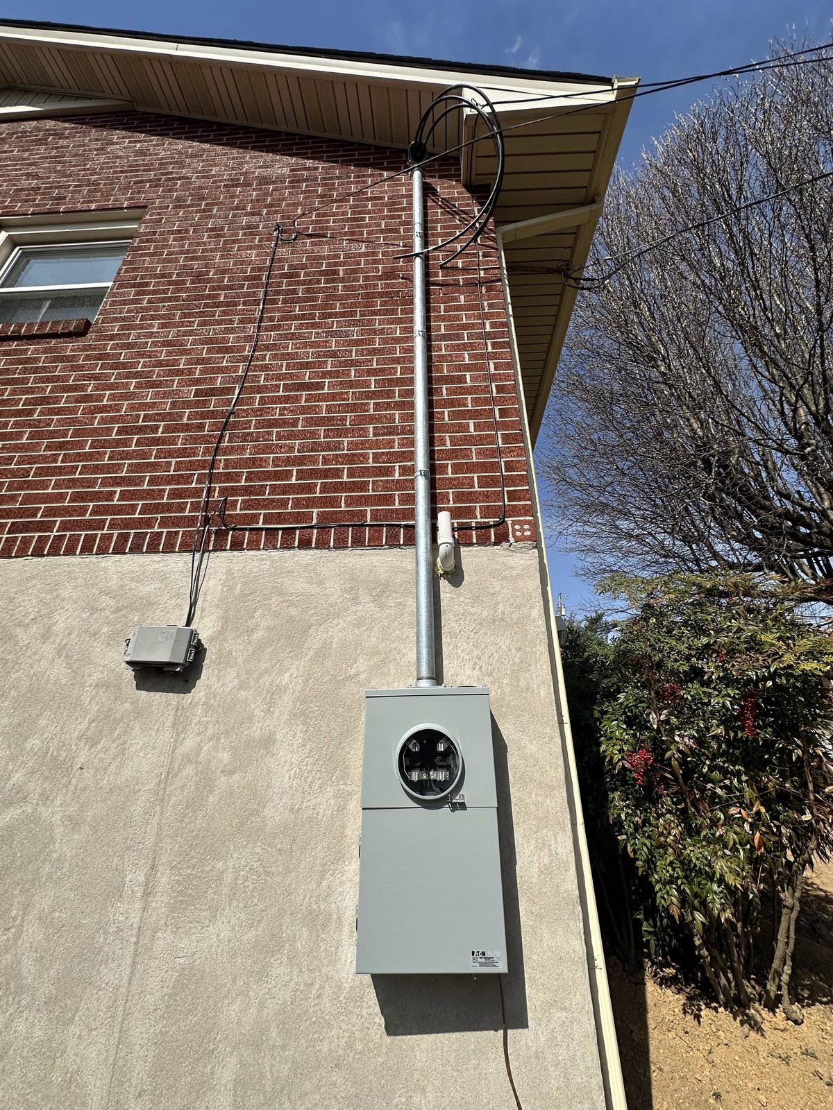 New meter-main and service mast on a brick and stucco home