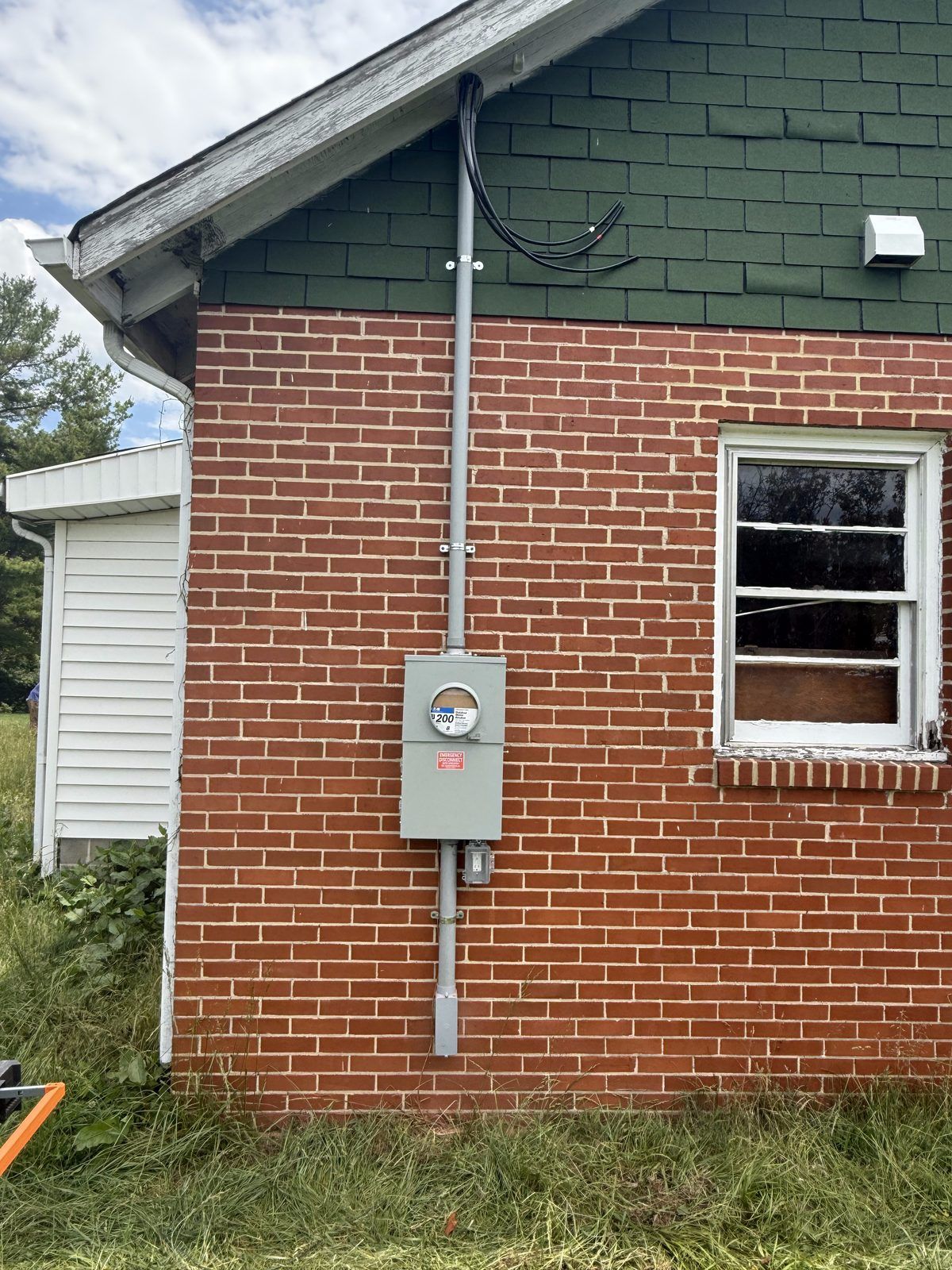 Finished meter base and service riser on a brick home